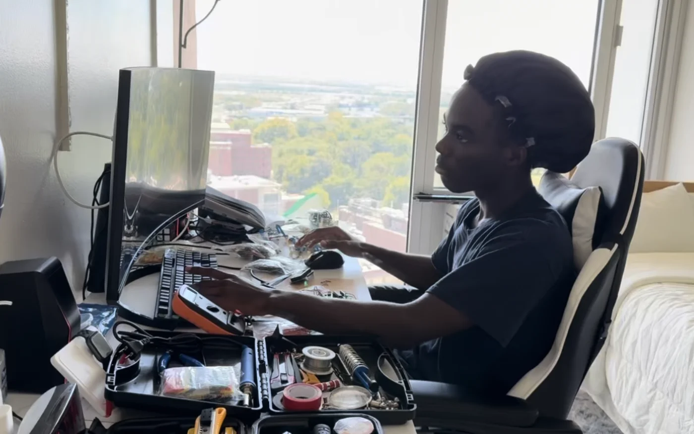 Tyrone working at his dorm desk, surrounded by electronics and test equipment