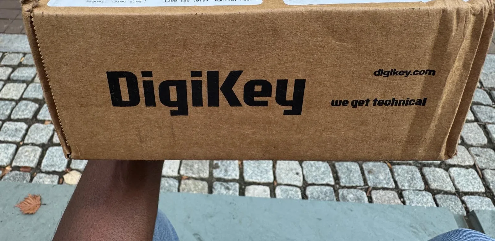 DigiKey overnight box — logo on the side, held over cobblestones.